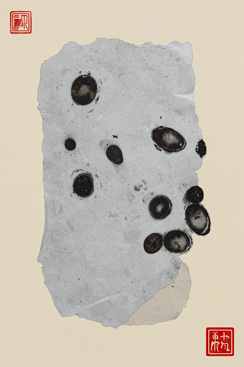 Abstract Ink Flow. A torn gray sheet marked with scattered black ink circles sits on cream paper, with small red seal-like symbols in opposite corners.