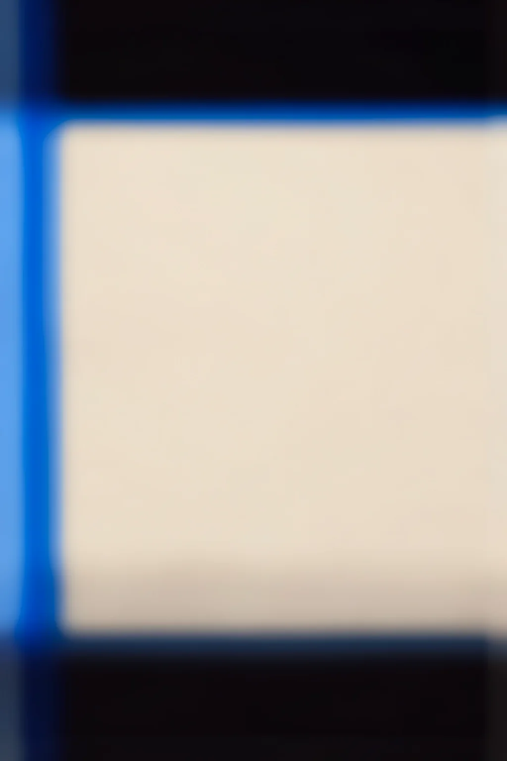 Blurred 13. Softly blurred dark navy and black bands frame a large pale cream center, with vivid blue along the left edge.