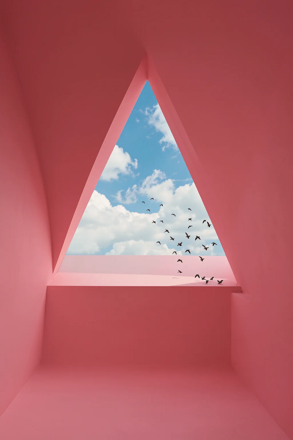Pink Geometric Sky. A triangular opening in a pink geometric room frames a blue sky with clouds and small birds.