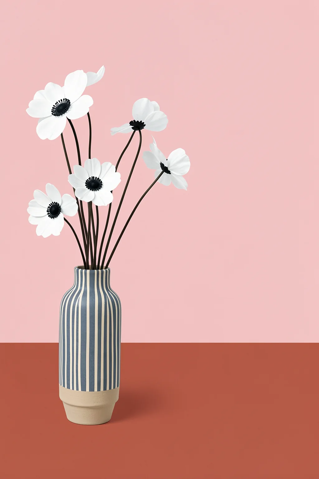 Blush Floral Vase. Five simple white flowers with dark centers rise from a blue-and-white striped vase against blush pink.