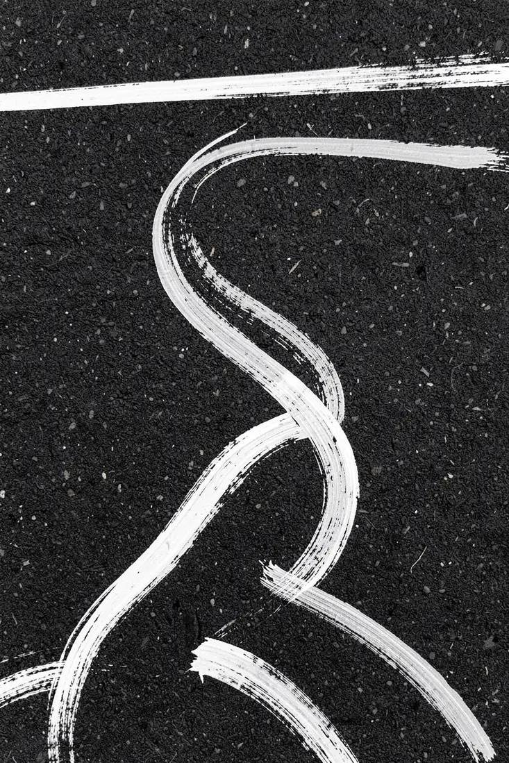 Monochrome Paths. Flowing white brushstrokes trace winding paths across a textured charcoal ground.