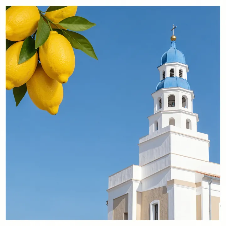 Santorini Neu. A white tower rises against a clear blue sky, with bright yellow lemons and green leaves hanging into the upper-left corner.