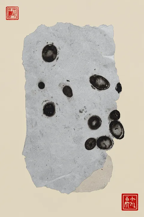 Abstract Ink Flow. A torn gray sheet marked with scattered black ink circles sits on cream paper, with small red seal-like symbols in opposite corners.