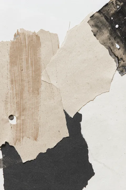 Clay. Layered torn-paper shapes in beige, gray, and charcoal overlap with vertical tan brush marks on a pale ground.