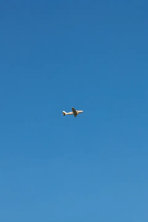 No stress. A small white airplane crosses an open, cloudless blue sky.