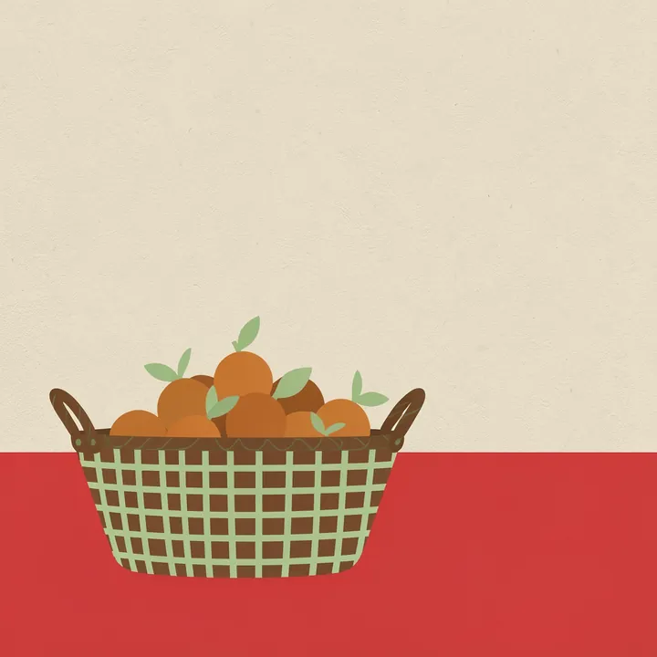 Modern Fruit Basket. A woven brown basket filled with round orange fruit sits on a red tabletop beneath a broad cream background.