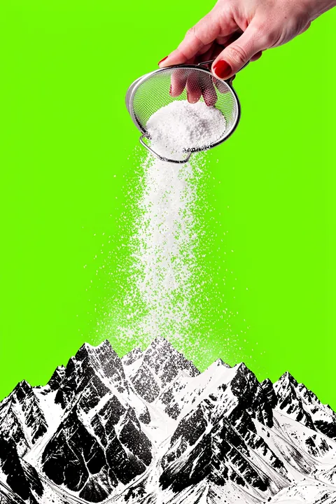 Sifting Powder Snow. A hand shakes white granular powder from a metal sieve above black-and-white mountain peaks against a vivid lime-green background.