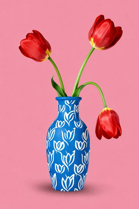 Tulpe in vase. Two upright red tulips and one drooping bloom rise from a blue vase patterned with white tulip motifs.