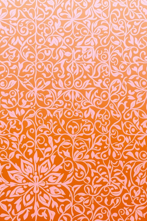 Ornate Floral Vines. An all-over ornamental pattern of pale pink floral vines and scrolls covers a peach-orange ground.